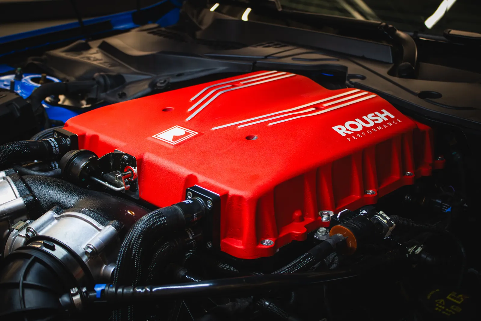 Red ROUSH supercharger installed in a Ford Mustang engine bay